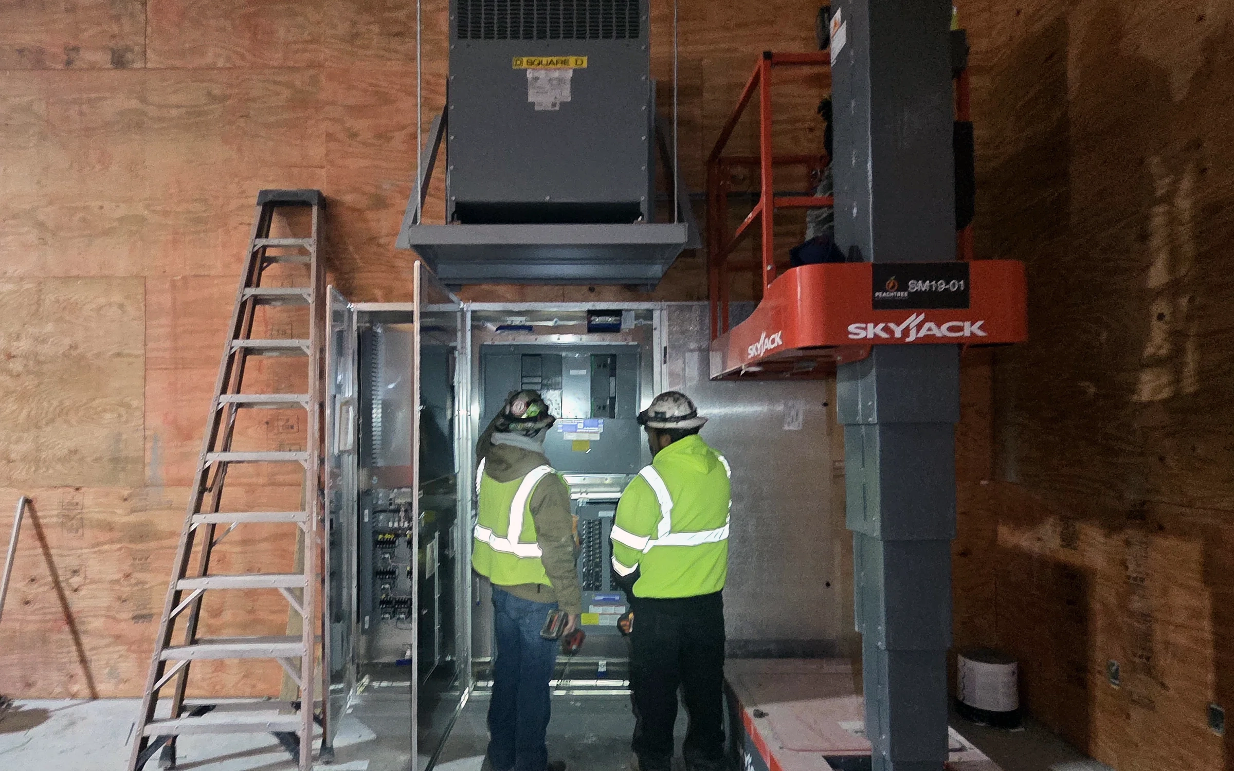 Electricians installing commercial distribution equipment